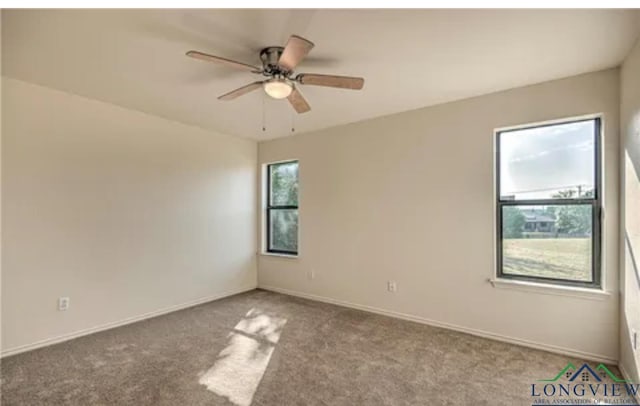 spare room featuring light carpet and ceiling fan