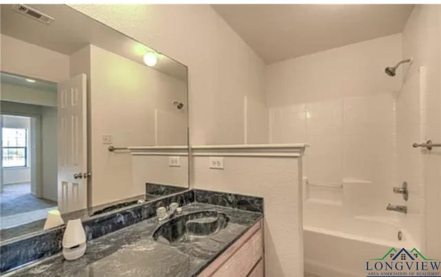 bathroom with vanity and shower / washtub combination