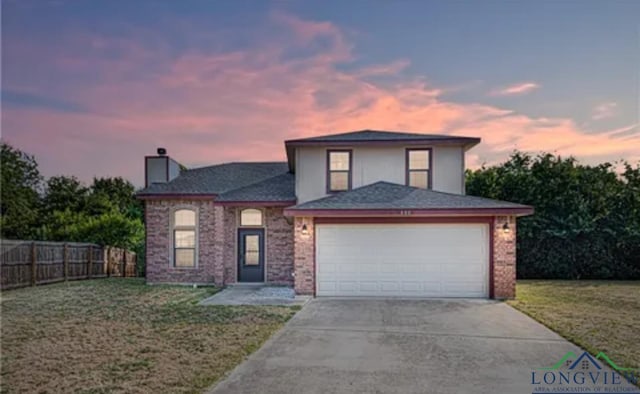 view of front of house featuring a garage and a lawn