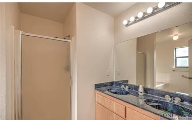 bathroom featuring vanity and a shower with door