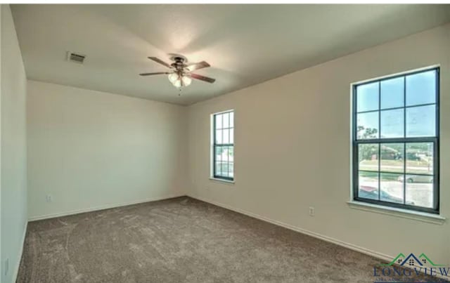 carpeted spare room with ceiling fan