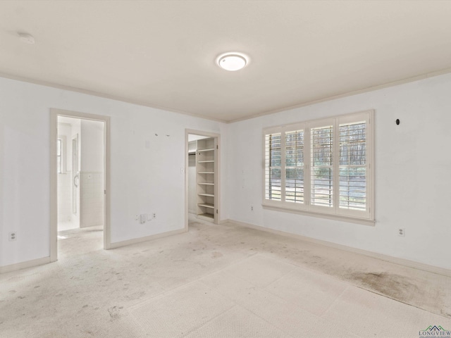 carpeted empty room featuring crown molding