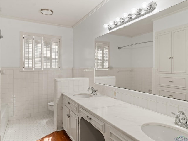 bathroom featuring ornamental molding, tile walls, vanity, and toilet