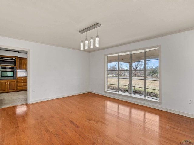 spare room with crown molding and light hardwood / wood-style floors