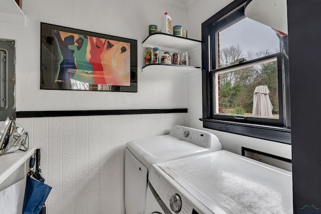 washroom featuring tile walls and washer and clothes dryer