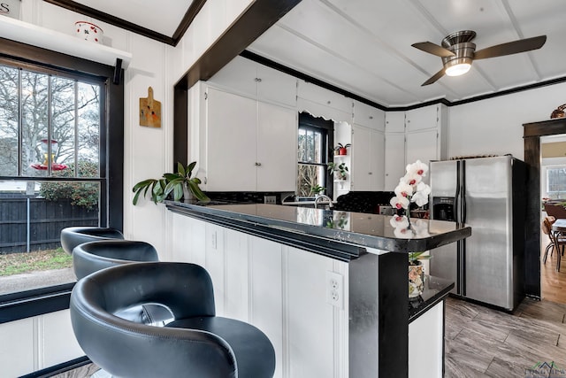 kitchen featuring sink, stainless steel fridge, ceiling fan, ornamental molding, and white cabinets