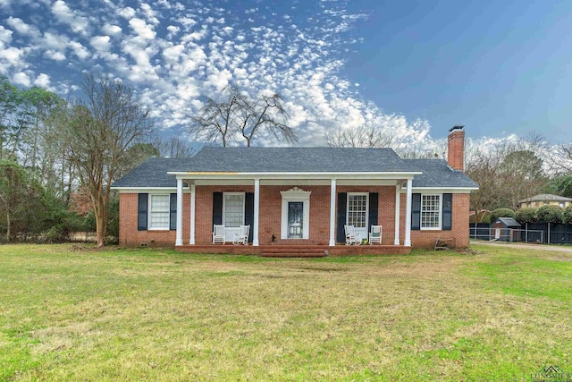 ranch-style home featuring covered porch and a front lawn