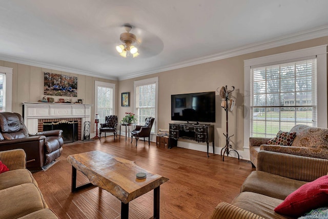 living room with hardwood / wood-style flooring, a fireplace, ornamental molding, and ceiling fan