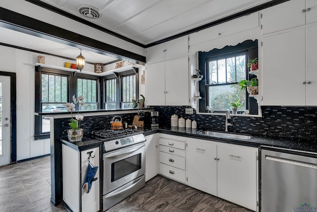 kitchen featuring white cabinetry, sink, dark stone counters, decorative backsplash, and stainless steel appliances