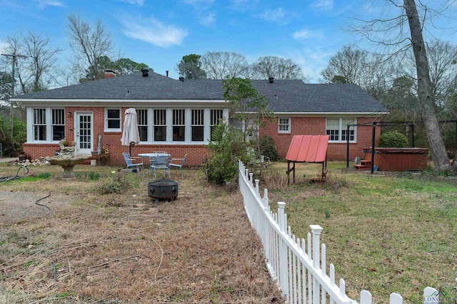 rear view of house featuring a hot tub