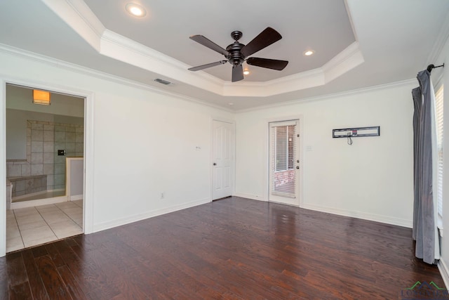 unfurnished room with visible vents, ornamental molding, wood finished floors, ceiling fan, and a tray ceiling