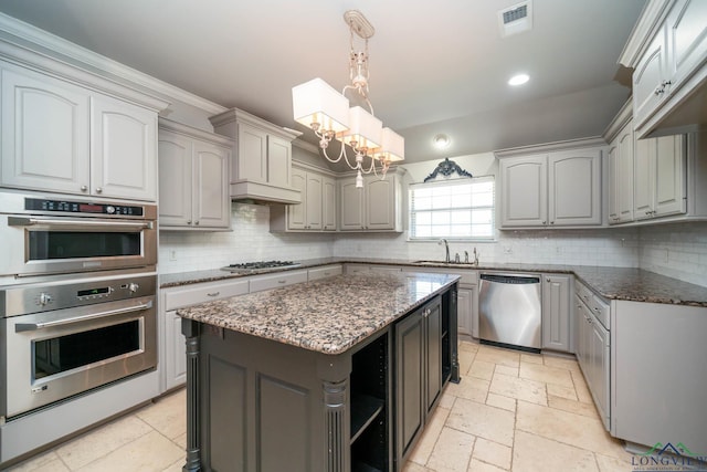 kitchen with gray cabinetry, appliances with stainless steel finishes, an inviting chandelier, and stone tile flooring