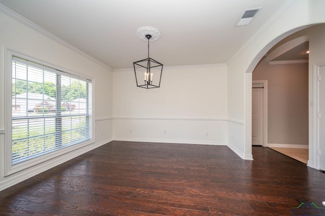 unfurnished dining area featuring arched walkways, baseboards, wood finished floors, visible vents, and ornamental molding