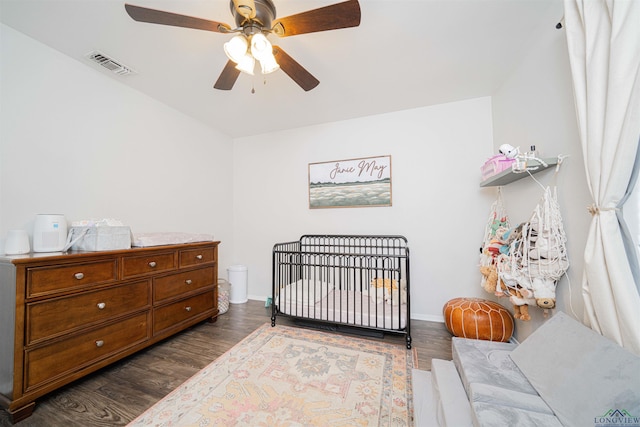 523 Molly Cir, Carthage, TX 75633 - bedroom featuring dark wood finished floors, a nursery area, and ceiling fan