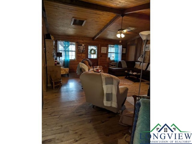 living room with dark hardwood / wood-style floors, wooden walls, vaulted ceiling with beams, ceiling fan, and wooden ceiling