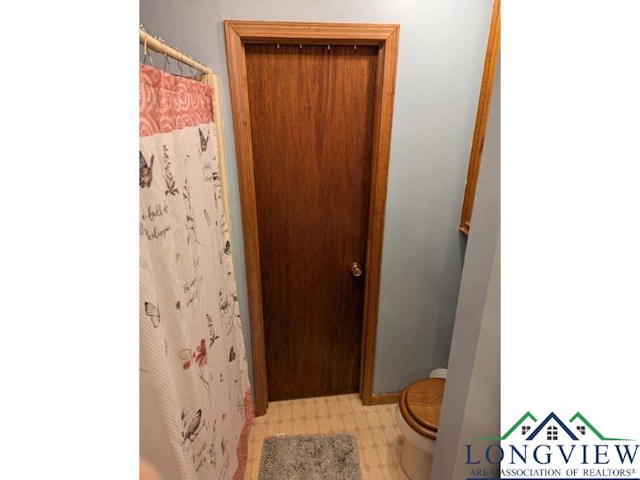 bathroom featuring a shower with shower curtain and toilet