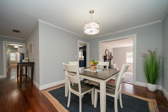 dining space with ornamental molding and dark wood-type flooring