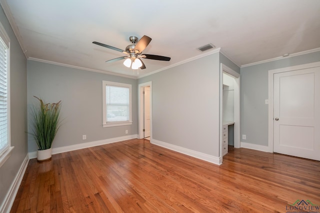 spare room featuring light wood-type flooring, ceiling fan, and ornamental molding