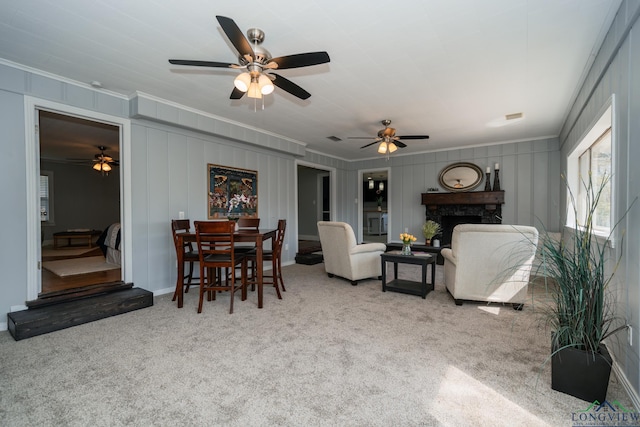 living room featuring crown molding, light colored carpet, and a fireplace