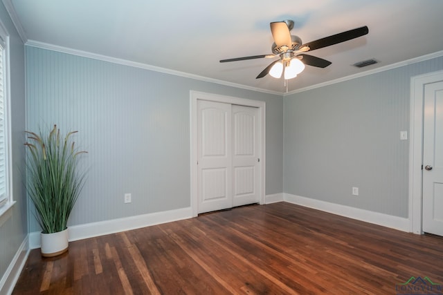 unfurnished bedroom with dark hardwood / wood-style flooring, a closet, ceiling fan, and ornamental molding