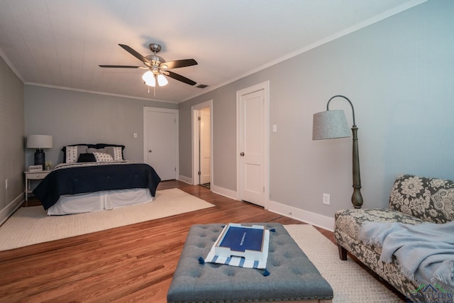 bedroom with hardwood / wood-style flooring, ceiling fan, and crown molding