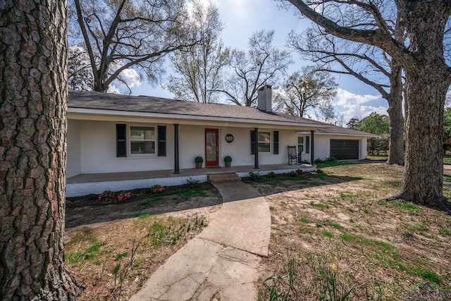 ranch-style home featuring covered porch and a garage