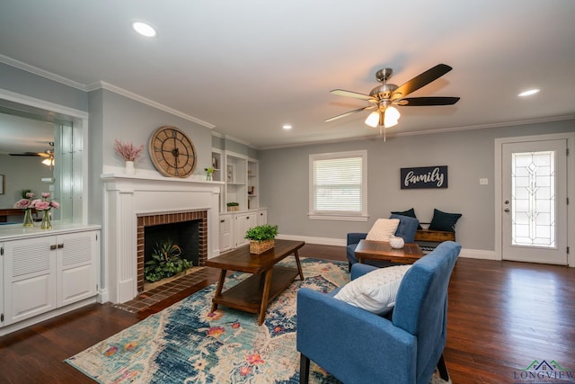 living room with built in shelves, dark hardwood / wood-style flooring, crown molding, and a brick fireplace