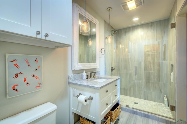 bathroom with toilet, vanity, visible vents, recessed lighting, and a stall shower