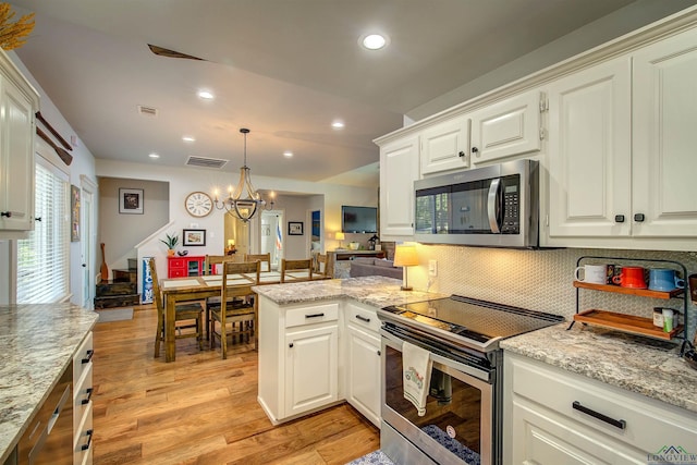 kitchen with recessed lighting, visible vents, a peninsula, backsplash, and appliances with stainless steel finishes
