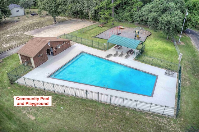 pool with a lawn, a patio area, and fence