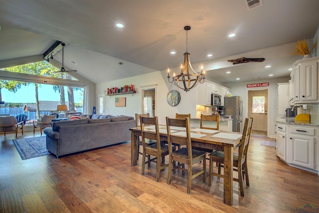 dining area featuring lofted ceiling with beams, visible vents, plenty of natural light, and wood finished floors