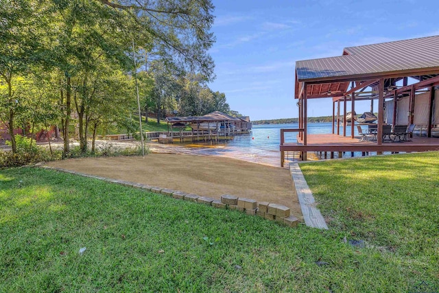 dock area with a yard, boat lift, and a water view