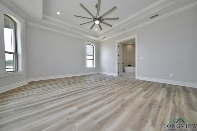 spare room with crown molding, ceiling fan, a tray ceiling, and light hardwood / wood-style floors