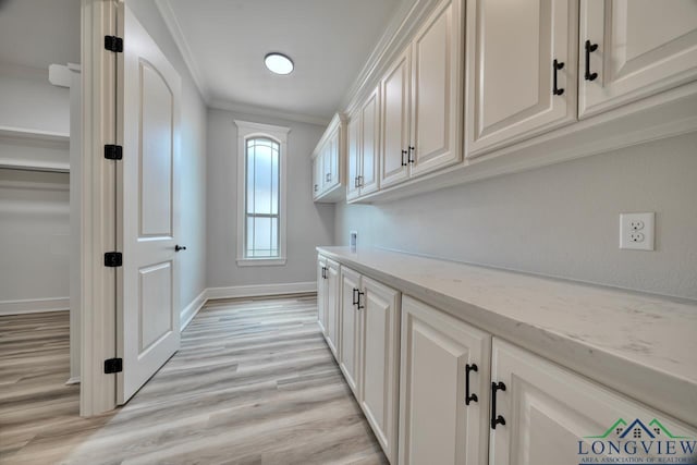 washroom with cabinets, ornamental molding, washer hookup, and light wood-type flooring