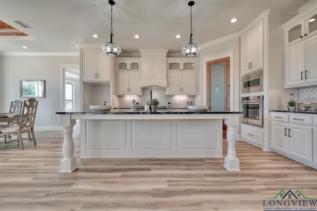 kitchen featuring pendant lighting, white cabinetry, a center island, and appliances with stainless steel finishes