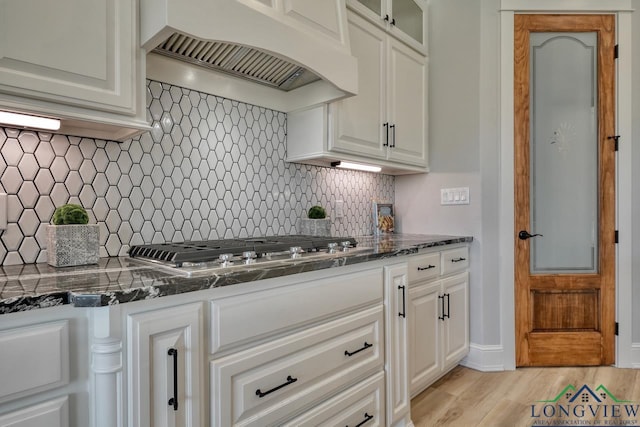 kitchen featuring stainless steel gas stovetop, light hardwood / wood-style floors, custom exhaust hood, and white cabinets