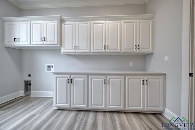 washroom with cabinets, ornamental molding, washer hookup, electric dryer hookup, and light wood-type flooring