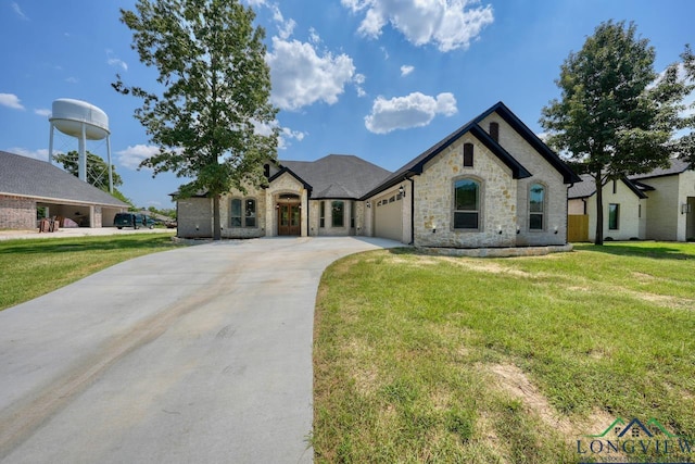 french country style house featuring a garage and a front yard