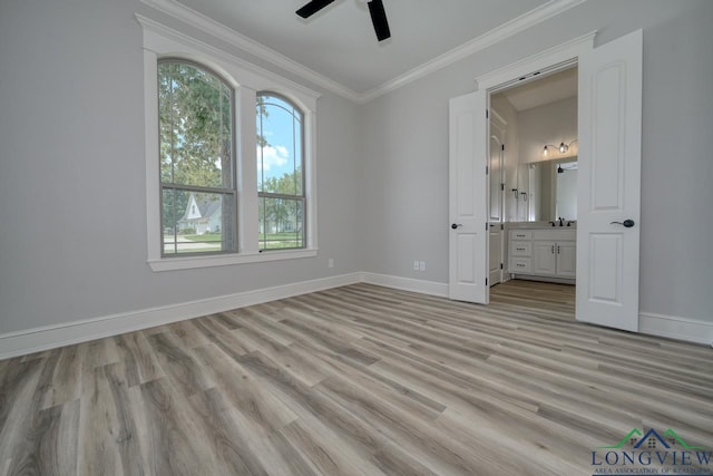 unfurnished bedroom featuring ensuite bathroom, sink, ornamental molding, ceiling fan, and light hardwood / wood-style floors