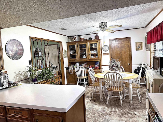 906 Misty Ln, Atlanta, TX 75551 - dining area with a ceiling fan, ornamental molding, and a textured ceiling