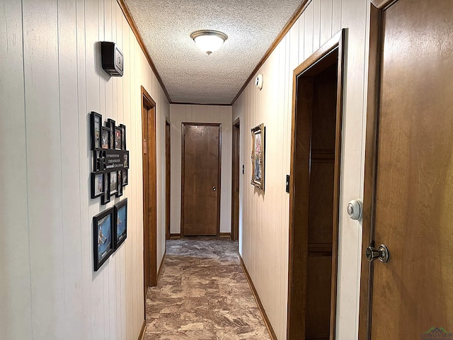906 Misty Ln, Atlanta, TX 75551 - hallway featuring ornamental molding, a textured ceiling, and wooden walls