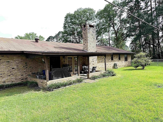 906 Misty Ln, Atlanta, TX 75551 - back of house with a chimney, brick siding, and a patio area