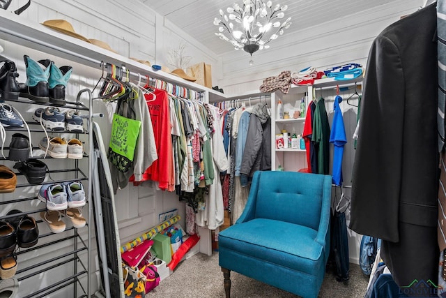 walk in closet featuring carpet floors and a notable chandelier