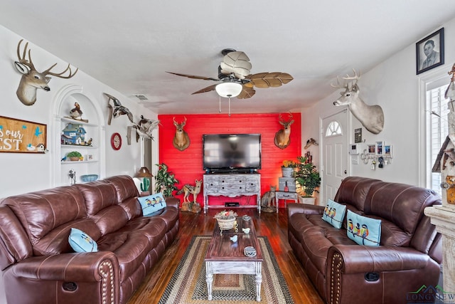 living room featuring hardwood / wood-style floors, built in shelves, and ceiling fan