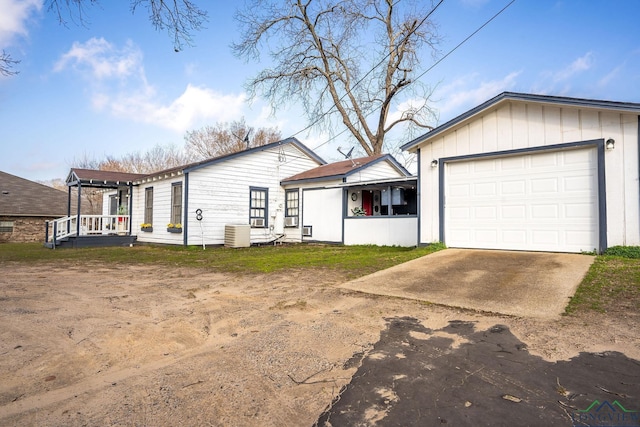 ranch-style home with a garage and central AC unit