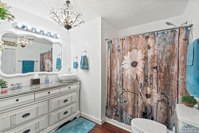 bathroom featuring toilet, a chandelier, hardwood / wood-style floors, and a textured ceiling