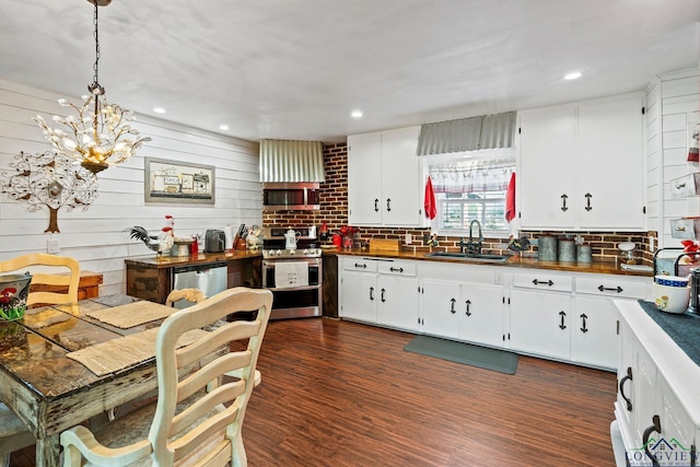 kitchen featuring white cabinetry, sink, hanging light fixtures, and appliances with stainless steel finishes