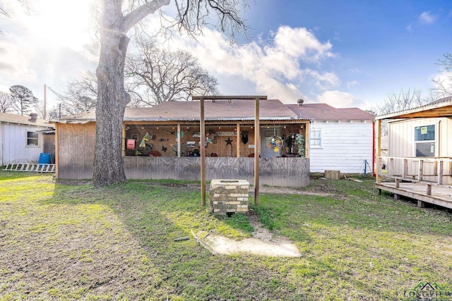 back of property featuring a wooden deck and a yard