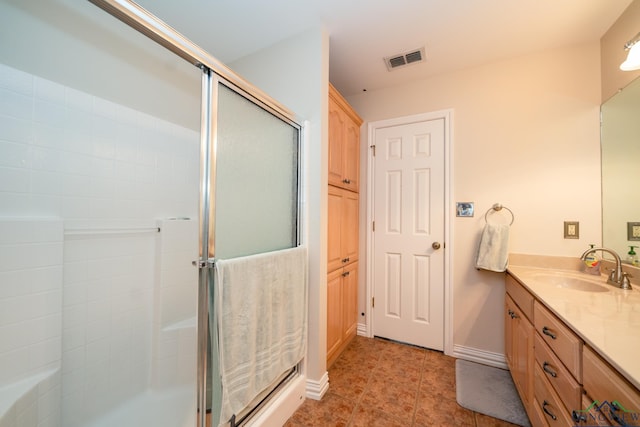 bathroom with tile patterned flooring, vanity, and an enclosed shower