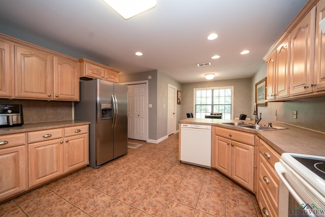 kitchen featuring white appliances, sink, light brown cabinetry, light tile patterned flooring, and kitchen peninsula